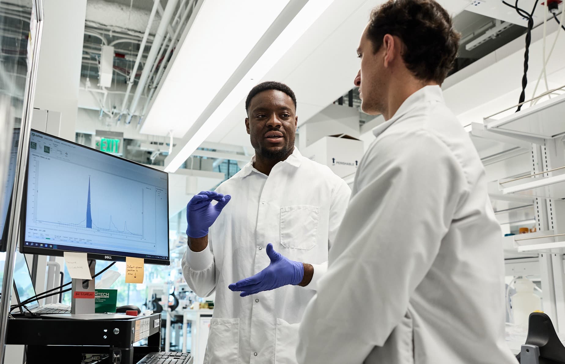 Uche Medoh in lab with scientist